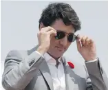  ??  ?? Prime Minister Justin Trudeau with the $300 sunglasses he received from P.E.I. Premier Wade MacLauchla­n.