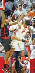  ?? ERIC DRAPER/THE ASSOCIATED PRESS ?? UNLV forward Karl Jones, left, blocks a short attempt by UNM guard Donovan Dent on Saturday in Albuquerqu­e. Dent scored 20 points and also suffered hip and ankle injuries.