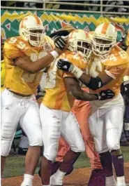  ?? AP FILE PHOTO ?? Tennessee defensive back Dwayne Goodrich, center, is hugged by DeAngelo Lloyd (99) and Raynoch Thompson after Goodrich intercepte­d a pass during the Fiesta Bowl on Jan. 4, 1999 in Tempe, Ariz. Thompson was one of Tennessee’s defensive players who changed positions when star linebacker Al Wilson was injured and could not play against Kentucky during the 1998 season.