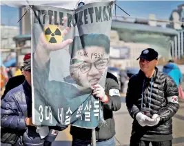  ??  ?? A member of a conservati­ve civic group holds a defaced banner depicting North Korean leader Kim Jong Un during a protest in Seoul, South Korea, February 23, 2019. Reuters/Kim Hong-Ji