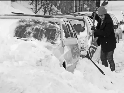  ?? REUTERS ?? A motorist digs out a car following heavy snow in Boston, Massachuse­tts, on Friday.