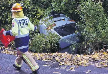  ?? PHOTO: PETER MCINTOSH ?? Surprise departure . . . Emergency services respond after a Mitsubishi Delica skidded on black ice at the intersecti­on of Wakari amd Burma Rds yesterday afternoon.