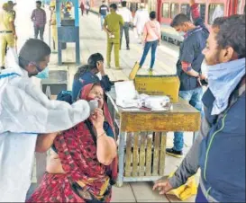  ?? ANSHUMAN POYREKAR/HT ?? A health worker collects swab sample of a passenger at Dadar station, on Sunday.