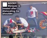  ??  ?? AGONY: Marquez is treated after dislocatin­g his shoulder