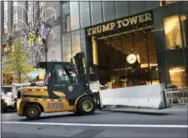  ?? SETH WENIG — THE ASSOCIATED PRESS FILE ?? In this file photo, police officers help to install concrete barriers around Trump Tower, the home of President-elect Donald Trump, in New York.