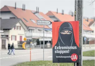  ?? AFP ?? A campaign poster, in favour of the ‘burqa ban’ initiative reading in German: ‘Stop extremism!’ is seen in Biberen near Bern on Sunday.