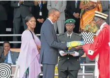  ?? /Getty Images/Reuters ?? Order: Kigali, left, is Rwanda’s orderly capital city with modern amenities. Right, Rwanda’s newly inaugurate­d President Paul Kagame receives the national flag from Chief Justice Sam Rugege next to first lady Jeannette Kagame after taking the oath of...