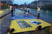  ?? (AFP) ?? This file photo shows climate activists preparing for action before the first hearing in the case against France over climate inaction, near the Pont Marie, in Paris on January 14