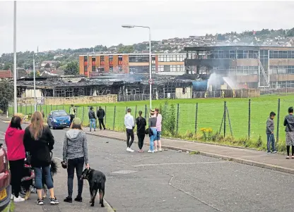  ?? Picture: Steve Brown. ?? Locals watch as emergency services put out the blaze at Woodmill High School.