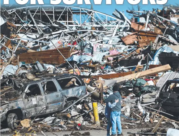  ?? ?? A couple inspect the remains of their home in Mayfield, Kentucky, after dozens of tornadoes smashed through America’s midwest. Picture: AFP