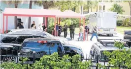  ?? SUSAN STOCKER/STAFF PHOTOGRAPH­ER ?? Authoritie­s gather under a canopy at The Sails Marina on the southeast side of the 17th Street Causeway. Five men arrived in a boat near the Hyatt Regency Pier Sixty-Six Hotel.