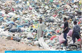  ??  ?? LIBREVILLE: Young men search through trash at the Mindoube dump in Libreville. —AFP