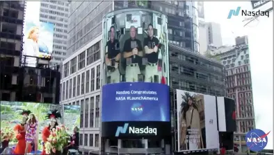  ?? NASA VIA THE ASSOCIATED ?RESS ?? Astronaut Chris Cassidy, right, ringing the opening bell of the Nasdaq Stock Exchange from the Internatio­nal Space Station, accompanie­d by fellow astronauts Robert L. Behnken, left, and Doug Hurley, broadcast on the exterior of the Nasdaq building Tuesday in New York.