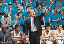  ?? Al Goldis / Associated Press ?? Teal-clad Michigan State students hoping to raise awareness about sexual violence stand behind Spartans coach Tom Izzo.