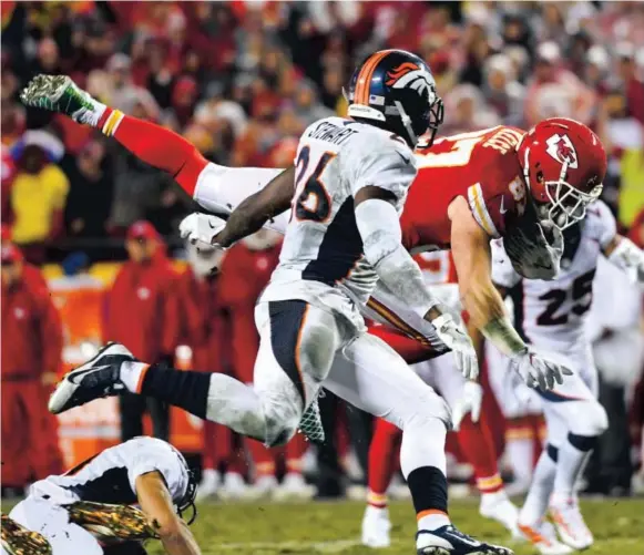  ??  ?? Kansas City Chiefs tight end Travis Kelce dives for a first down against the defense of Broncos safety Darian Stewart during the first half Sunday night at Arrowhead Stadium. Kelce had a huge game, catching 11 passes for 160 yards, including an 80-yard...