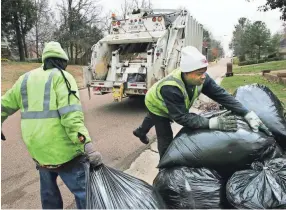  ??  ?? Brandon Jackson, left, and Ray Joyce pick up trash on Windy Oaks Drive in Germantown. The city, like Memphis, has levied heavy fines against Inland Waste Solutions for the untimely collection of garbage. A.J. WOLFE / THE COMMERCIAL APPEAL