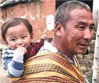  ?? PHOTOS GARY LAWRENCE ?? Une vénérable Bhoutanais­e marque une pause à Chanangkha Lhakang, le temple de la Fertilité, à Thimphu. À droite: au Tshering Farmhouse, une ferme-auberge près de Paro, grand-papa trimballe petit-fiston sur son dos.