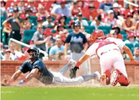  ?? ASSOCIATED PRESS PHOTOS ?? The Atlanta Braves’ Ronald Acuna Jr., left, celebrates as he scores past St. Louis Cardinals catcher Francisco Pena during the sixth inning of Sunday’s game in St. Louis.