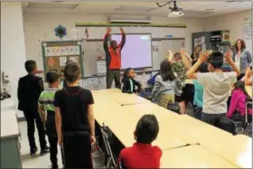  ?? TAWANA ROBERTS — THE NEWS-HERALD ?? Darryl Lewis, a profession­al singer, composer, playwright and actor, teaches Maple Elementary School third-graders about song writing and music on May 12.