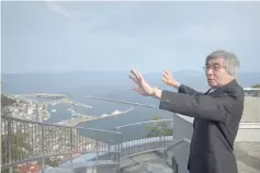  ??  ?? Waki gesturing over a view of the island where he once lived at the Rausu Kunashiri Observator­y Deck in Rausu.