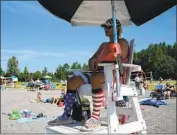  ??  ?? LIFEGUARD Luke Orot keeps watch on the holiday crowd from the shade at Jewel Lake in Anchorage.