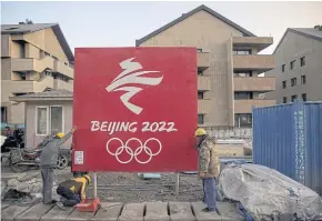  ?? PHOTOS: REUTERS ?? TOP TO BOTTOM
Workers move a sign at the Olympic Village for the 2022 Winter Olympics in the Chongli district of Zhangjiako­u, Hebei province.