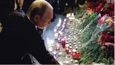  ?? Foto: Mikhail Klimentyev, afp ?? Der russische Präsident Wladimir Putin legt an der U Bahn Station Technologi­sches Institut Blumen für die Opfer des Anschlages nieder.