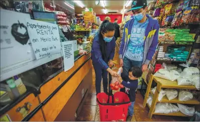  ?? PHOTOS BY RAY CHAVEZ — STAFF PHOTOGRAPH­ER ?? Yadira Mederos de Cardenas, left, along with her children Isaac Cardenas, 16, and 22-month-old Nikolaas Cardenas, of Menlo Park, shop for produce at a Mexican market in Menlo Park on Oct. 31.