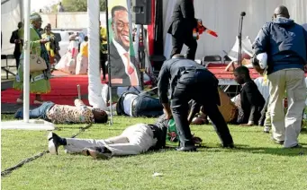  ?? AP ?? Injured people lay on the ground following an explosion at a Bulawayo stadium where President Emmerson Mnangagwa was addressing a campaign rally.