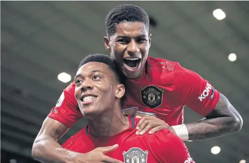  ??  ?? Manchester United’s Anthony Martial, front, celebrates scoring a goal with Marcus Rashford.