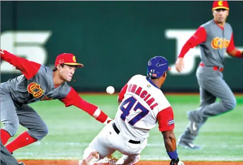  ?? TOSHIFUMI KITAMURA / AFP ?? Yurisbel Gracial of Cuba steals second base before Team China’s Du Xiaolei can make the catch during the second inning of Wednesday’s World Baseball Classic Pool B game at the Tokyo Dome. Cuba won 6-0. Team China faces Australia tonight and Japan on...