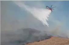  ?? — AFP ?? Firefighte­rs drop water on the area near to the Reagan Library during the Easy Fire in Simi Valley, California.