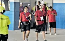  ??  ?? Voluntario­s recorren los pasillos del Édgar Rentería para brindar apoyo a los asistentes.