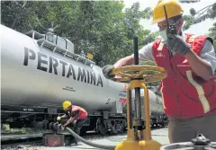  ??  ?? Pertamina workers unload fuel at a terminal in Pematang Siantar, North Sumatra.