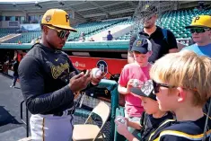  ?? CHARLIE NEIBERGALL THE ASSOCIATED PRESS ?? Pittsburgh Pirates second baseman Termarr Johnson signs autographs Saturday before a spring training game against the Detroit Tigers in Lakeland, Fla.