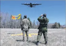  ?? COLIN MACLEAN/JOURNAL PIONEER ?? Major Vincent Meunier, left and Cpl. Steeve Bedard watch as a CC-130 Hercules prepares to make a drop during a recent search and rescue training exercise.