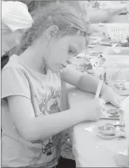  ?? Keith Bryant/The Weekly Vista ?? Dannika Venter, 6, works on a card for either firefighte­rs or police officers. Venter changed her mind multiple times, but her eyes stayed on the prize the whole way. She was working on the card, she said, to get ice cream.