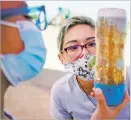  ??  ?? Jamie Torres looks at her student Asa Castillo Johnson’s sensory bottle completed during a science lesson Thursday at Kearny Elementary School.