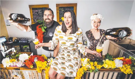  ?? Picture: Nigel Hallett ?? CARNIVAL TIME: Maddison Cross gets a taste of the Orange Blossom beer from 4 Brothers Brewing owners Adrian Cubit (left) and Josie Adams ahead of the 2021 Toowoomba Carnival of Flowers.