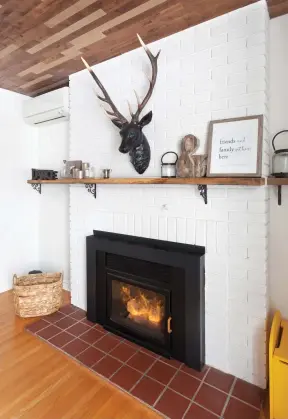  ??  ?? Trônant au coeur de l'espace, le coin foyer a été brillammen­t revigoré. La brique peinte en blanc charme dès le premier regard, alors que la tête de cerf décorative est un réel clin d'oeil au look chalet, bien imposé dans ce décor à la fois chic et champêtre.