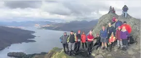  ??  ?? Breathtaki­ng The high walkers at the summit of Ben A’an with a stunning view of Loch Katrine