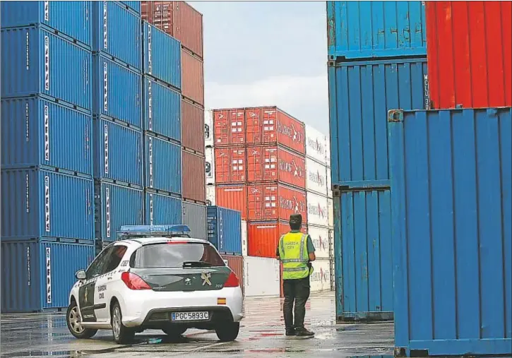  ??  ?? Un agente de la Guardia Civil, en la terminal de contenedor­es del puerto de Barcelona por donde entra parte de la mercancía que acaba luego en la venta ambulante