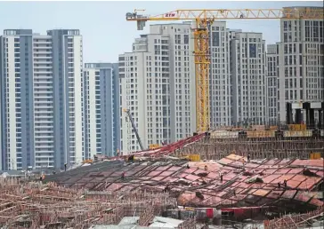  ?? — Reuters ?? Stimulatin­g demand: A constructi­on site in Shanghai. The PBOC has lowered mortgage rates and down payments to support basic home buying.