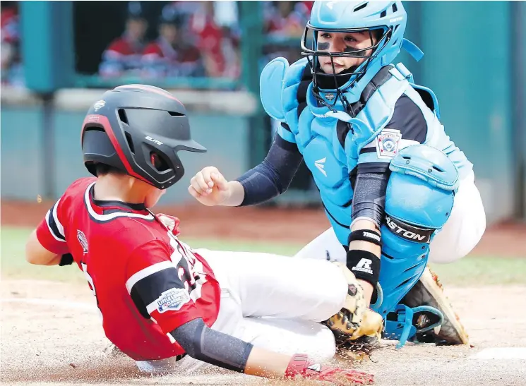  ?? — THE ASSOCIATED PRESS ?? Puerto Rico catcher John Lopez tags out Canada’s Cole Balkovec in an eliminatio­n game Wednesday at the Little League World Series in Pennsylvan­ia.