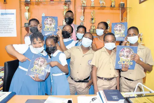  ?? NICHOLAS NUNES/PHOTOGRAPH­ER ?? Jessie Ripoll Primary School students share excitement after receiving copies of the Best in Class Book on May 17, 2022. With them are principal O’Neil Stevens (at back) and Grade 5 teacher Antoinette Perkins-Chen (third right).