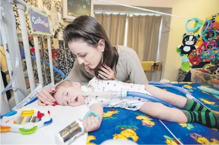  ?? DARREN STONE, TIMES COLONIST ?? Cindy Dent comforts 11-month-old Gabriel Dent in the pediatric intensive care unit at Victoria General Hospital.