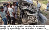  ?? — PTI ?? People look at the mangled remains of a jeep which was hit by a sand- laden tractor- trolley, in Morena in Madhya Pradesh on Thursday.