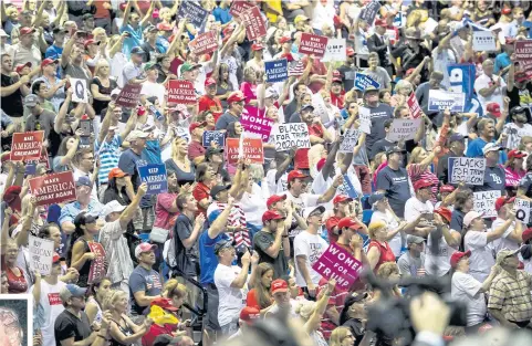 ?? BLOOMBERG ?? Attendees hold placards and cheer during a rally with US President Donald Trump, inset, in Tampa, Florida on Tuesday. Iranian Foreign Minister Javad Zarif has pushed back on Mr Trump’s suggestion that he would be willing to meet President Hassan...