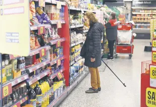  ?? ?? A shopper reads a price tag in a supermarke­t in London, U.K., Oct. 19, 2022.