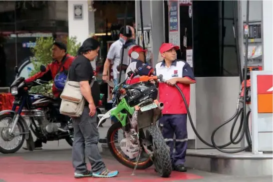  ?? Photo by Milo Brioso ?? FUEL HIKE AGAIN. Motorist fill up their gas tanks as local fuel stations implement price hike anew after two consecutiv­e weeks of price rollbacks.